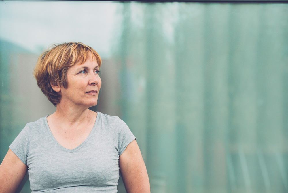 613021874 Independent Senior woman with short hair against window glass reflection portrait - outdoors photography. Slovenia, Europe. All logos removed. Nikon D800, full frame, Nikkor 70.0-200.0 mm, aperture 2.8, Copy space.